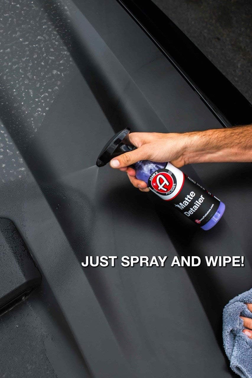 Hand spraying cleaner on a black car floor mat, with text "JUST SPRAY AND WIPE!"
