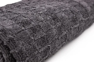 Dark gray textured towel rolled on a white background
