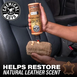 Hand applying leather cleaner to a car seat, restoring natural leather scent.
