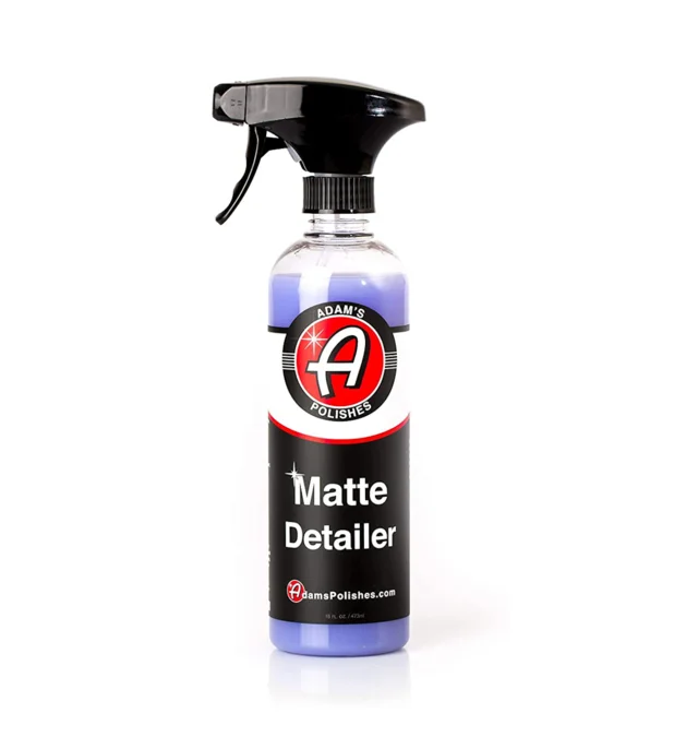 Black spray bottle of matte detailer with red-and-white label on a white background