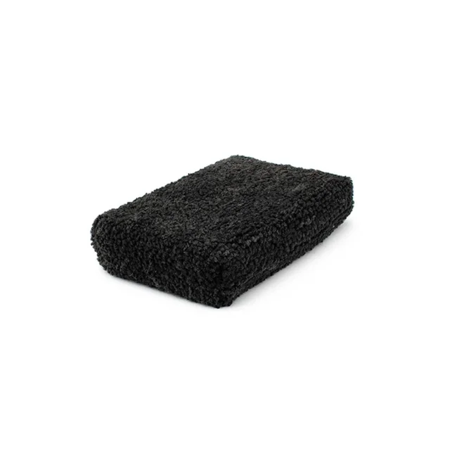 Black rectangular textured sponge on a white background