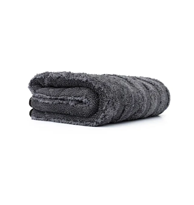 Rolled dark gray towel on a white background