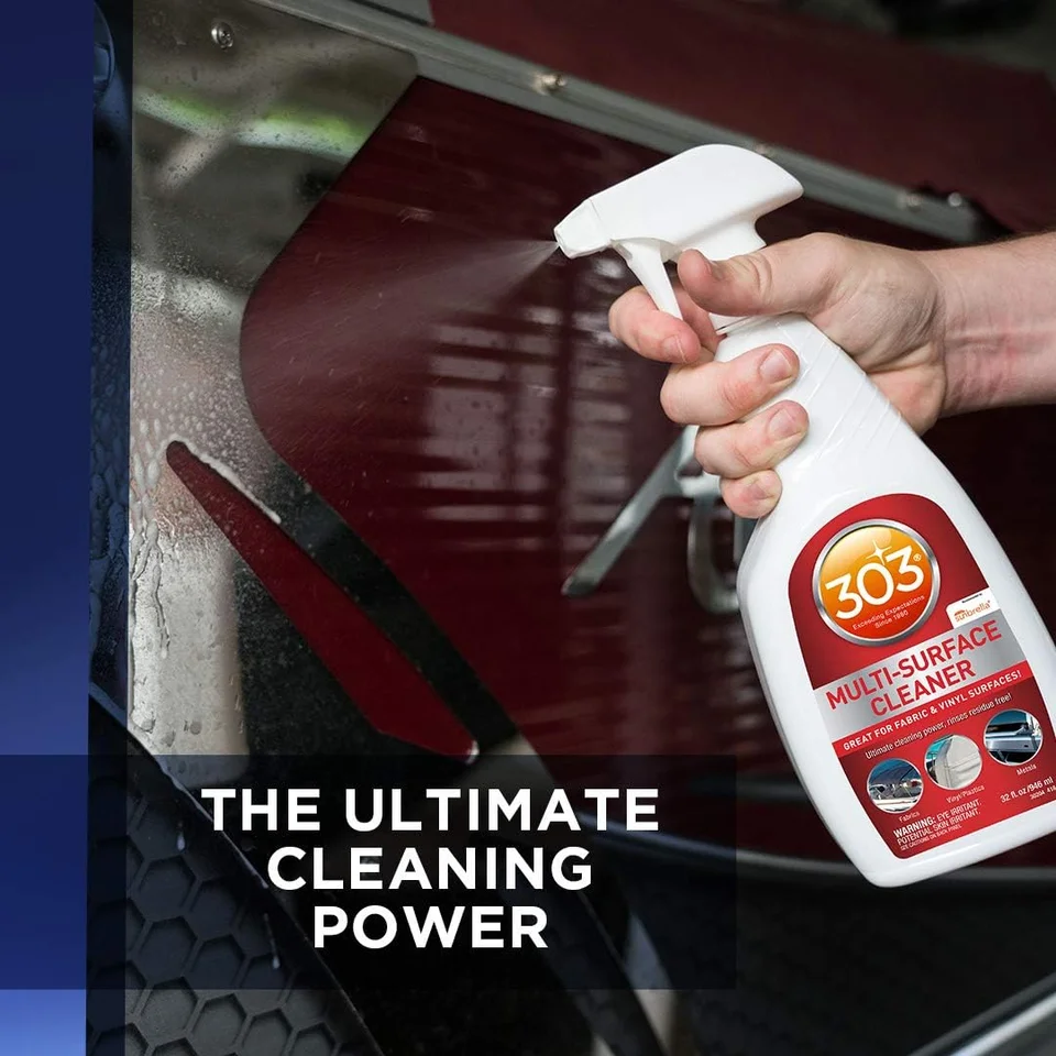 Hand holding a 303 spray bottle over a glossy red car hood.