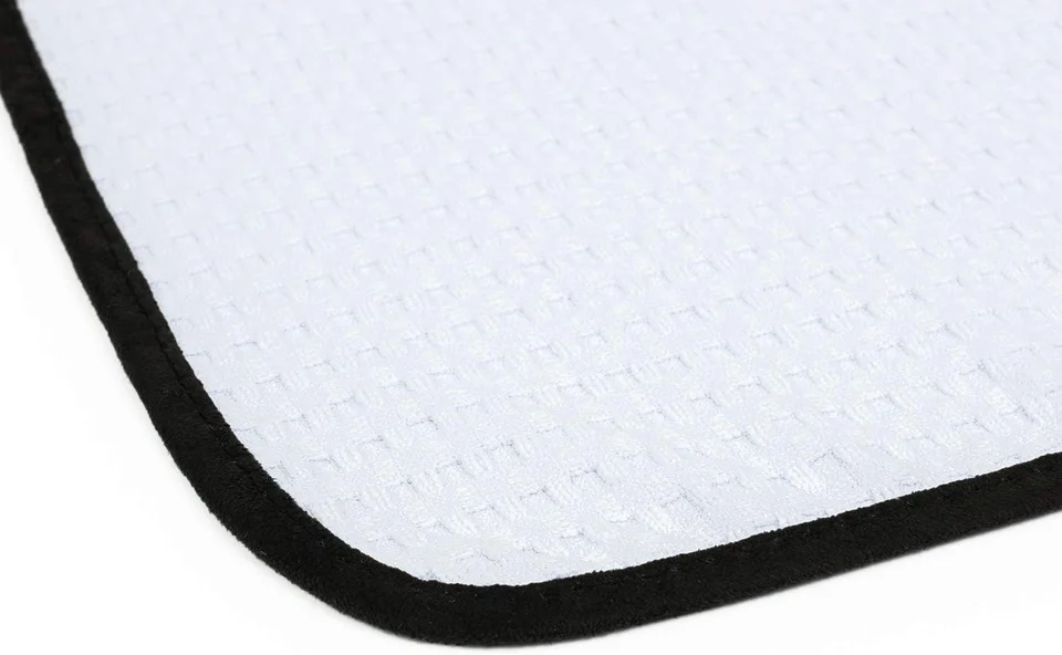 White textured mat corner with black trim on a white background