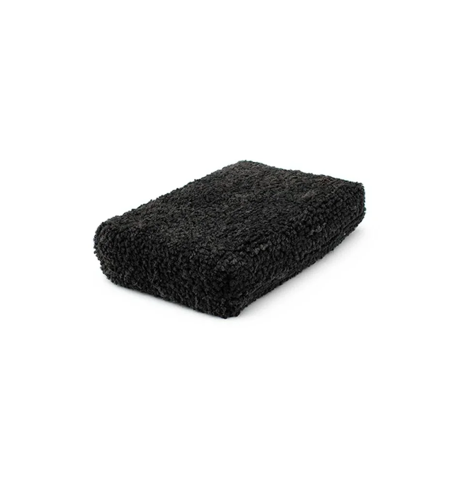 Black rectangular textured sponge on a white background