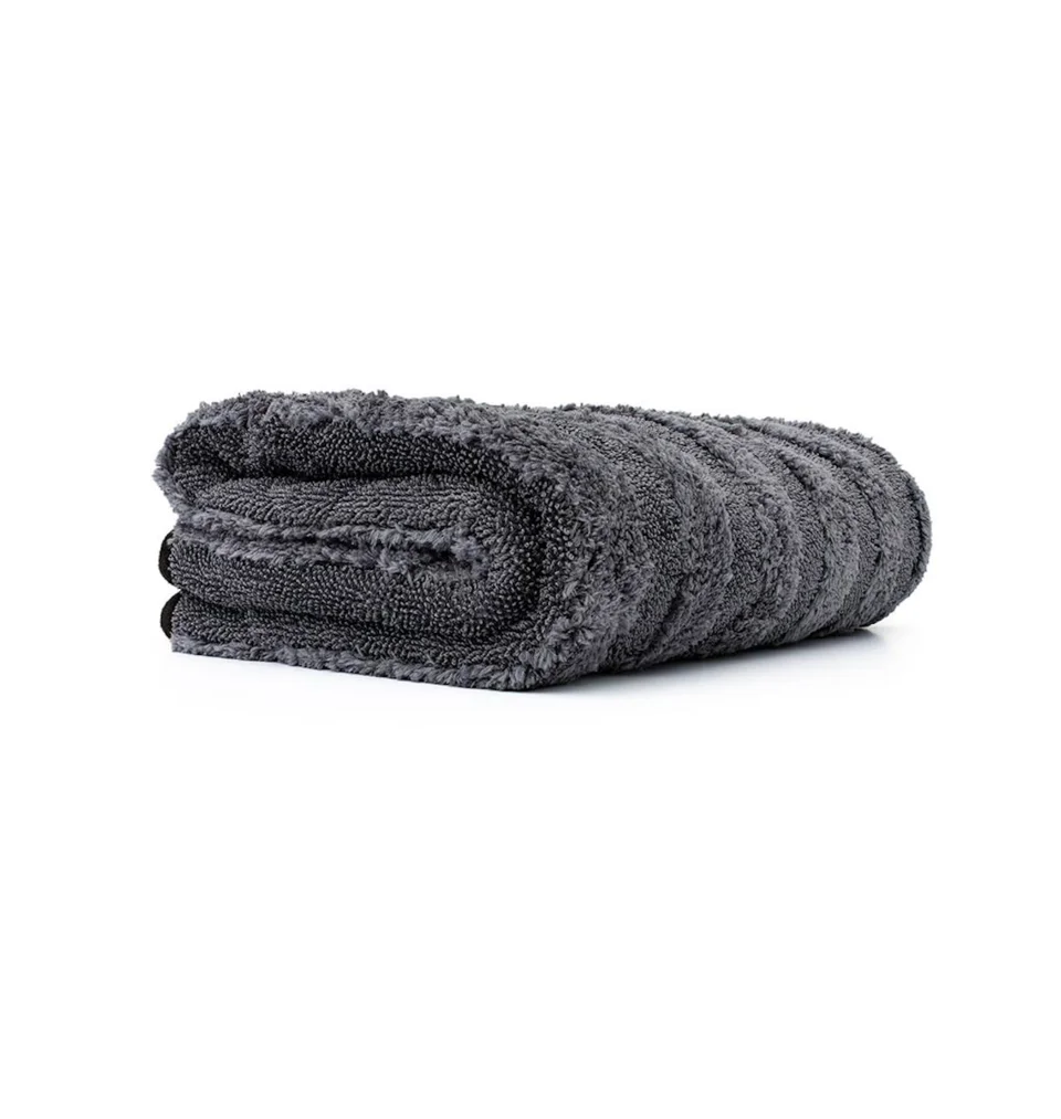 Rolled dark gray towel on a white background