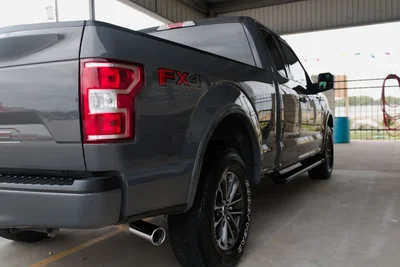 Black Ford F-150 FX4 pickup truck parked under a covered structure.